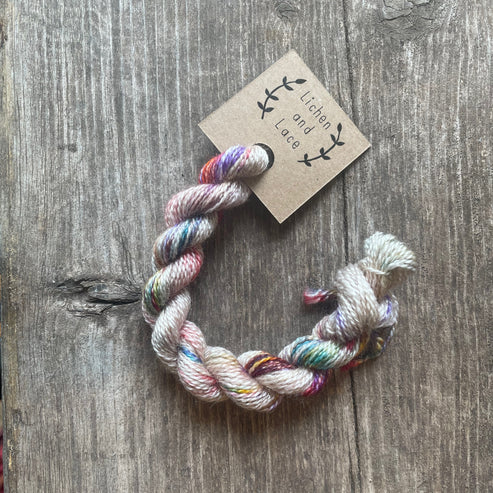 A skein of Pressed Flowers variegated embroidery yarn labelled 'Lichen and Lace'.