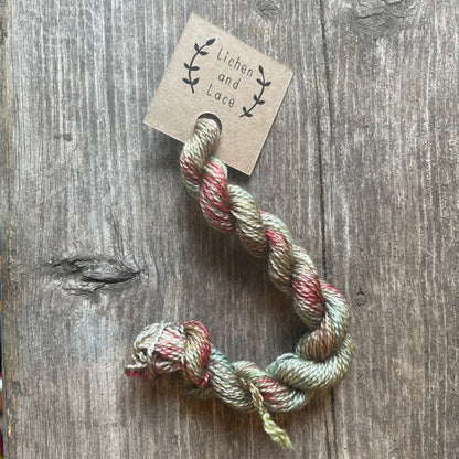 A skein of Sea Grass green embroidery yarn labelled 'Lichen and Lace'.