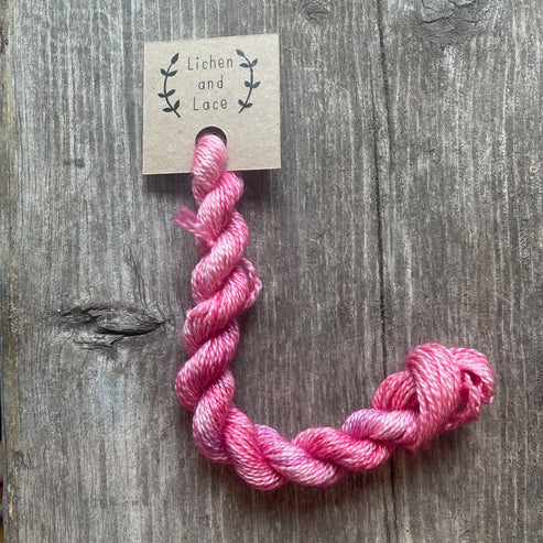 A skein of Sweetpea pink embroidery yarn labelled 'Lichen and Lace'.