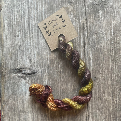 A skein of Woods brown embroidery yarn labelled 'Lichen and Lace'.