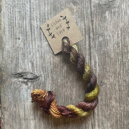 A skein of Woods brown embroidery yarn labelled 'Lichen and Lace'.