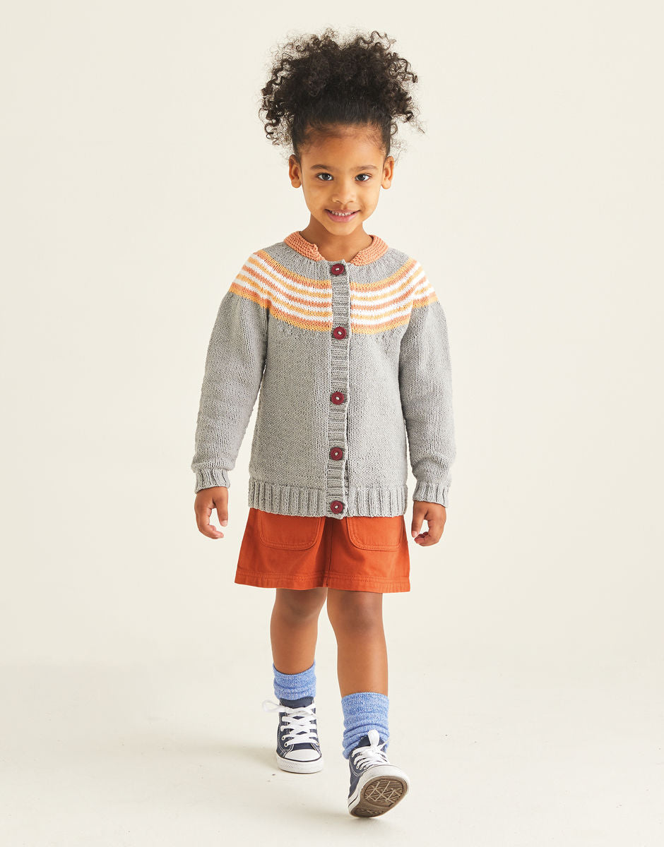 Child wearing a gray cardigan with orange  yoke detailing and an orange skirt on a white background
