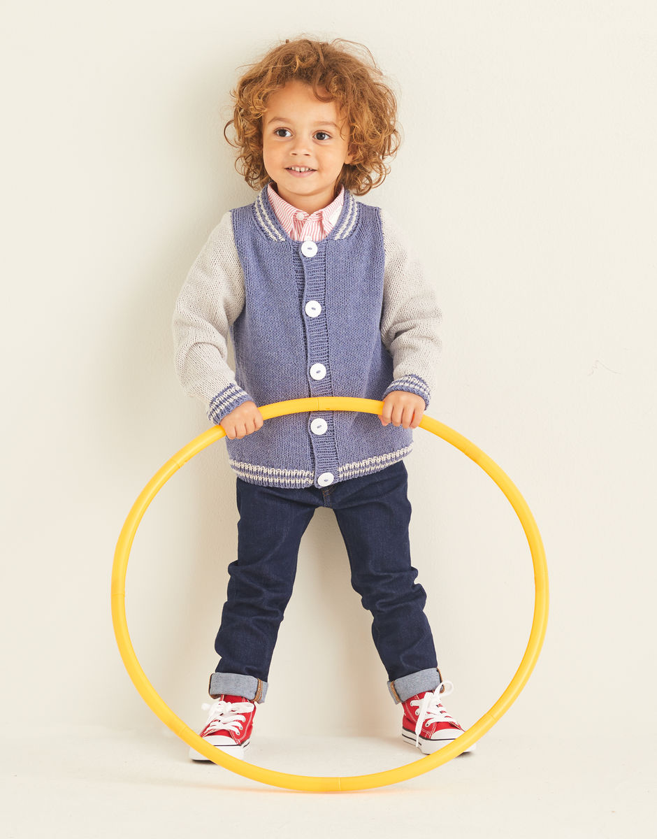 Child wearing a knit varsity jacket in pale blue and cream, holding a yellow hula hoop against a plain background