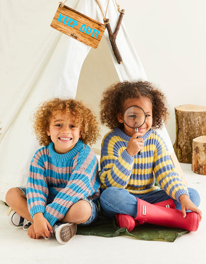 Two children in colorful sweaters sitting inside a teepee with a 'Keep Out!' sign.