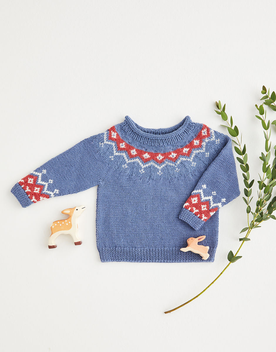 Blue knitted sweater with red and white yoke pattern on a light gray background