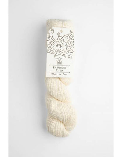 Cream-colored skein of yarn with a label on a light gray background
