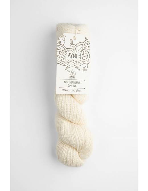 Cream-colored skein of yarn with a label on a light gray background