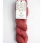 Red skein of yarn with a label on a white background