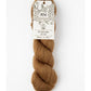 Brown skein of yarn with a label on a white background