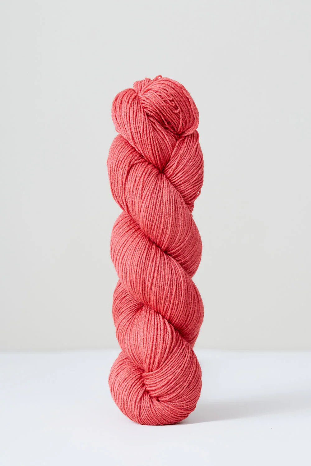 A skein of salmon pink superwash merino wool from Urth 