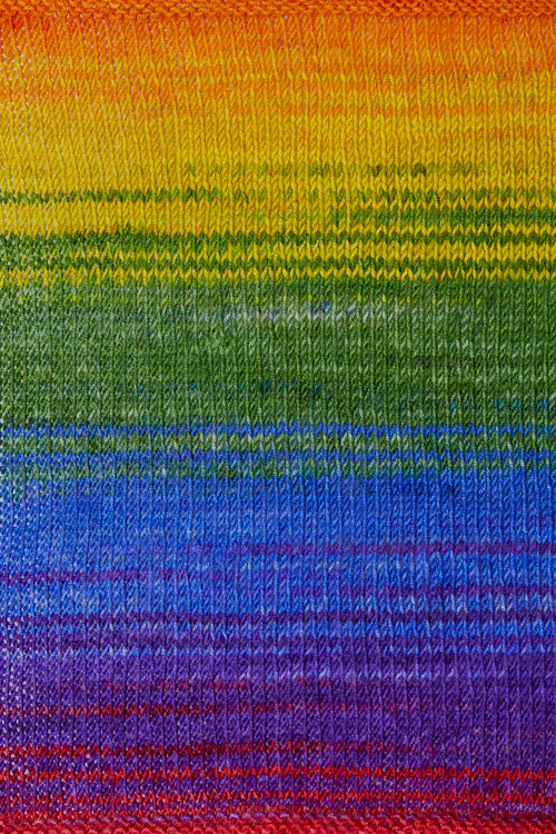 a knitted swatch of merino yarn with a rainbow gradient tone from Urth yarns