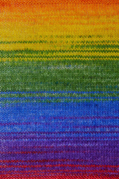 a knitted swatch of merino yarn with a rainbow gradient tone from Urth yarns