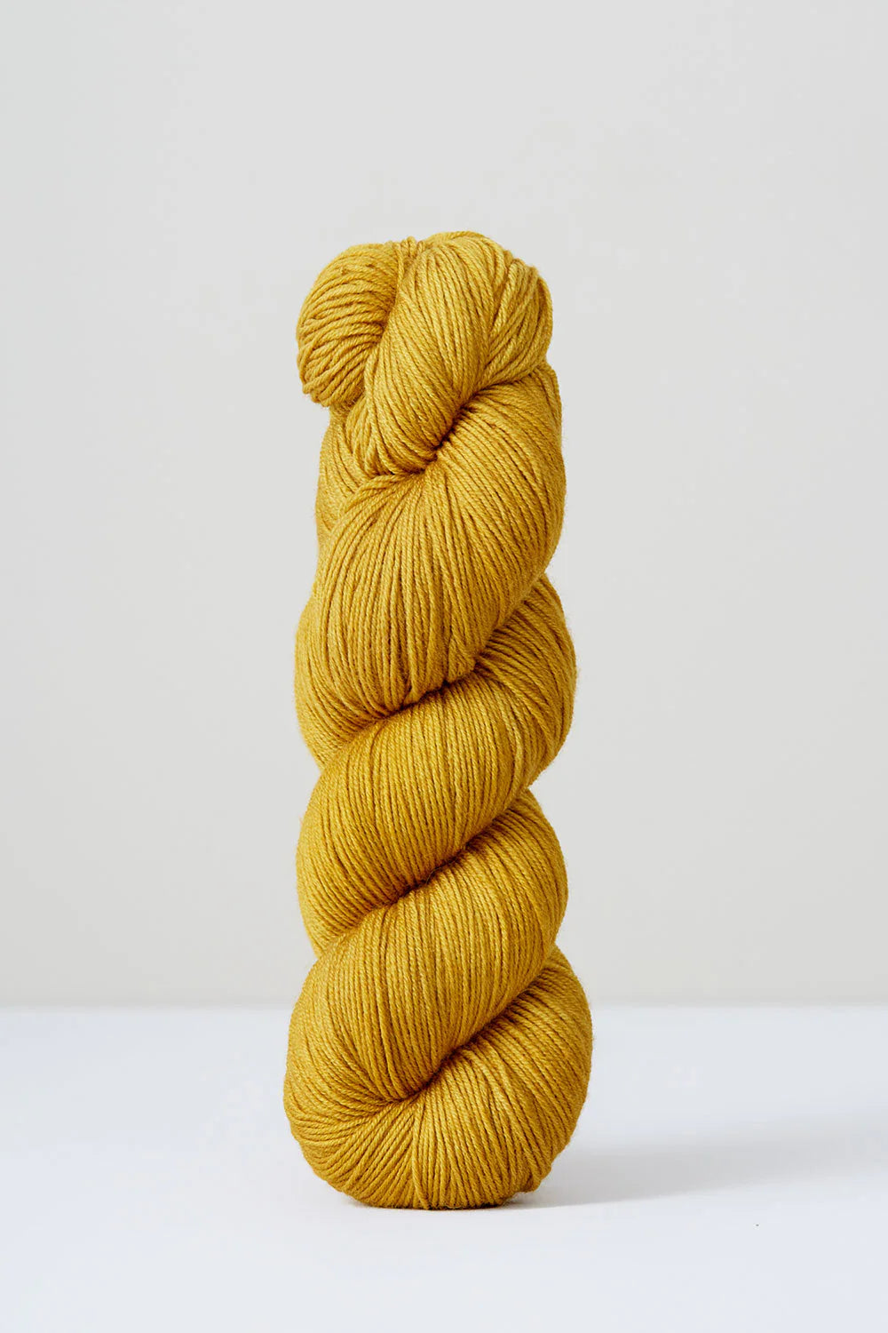 A skein of golden yellow superwash merino wool from Urth 