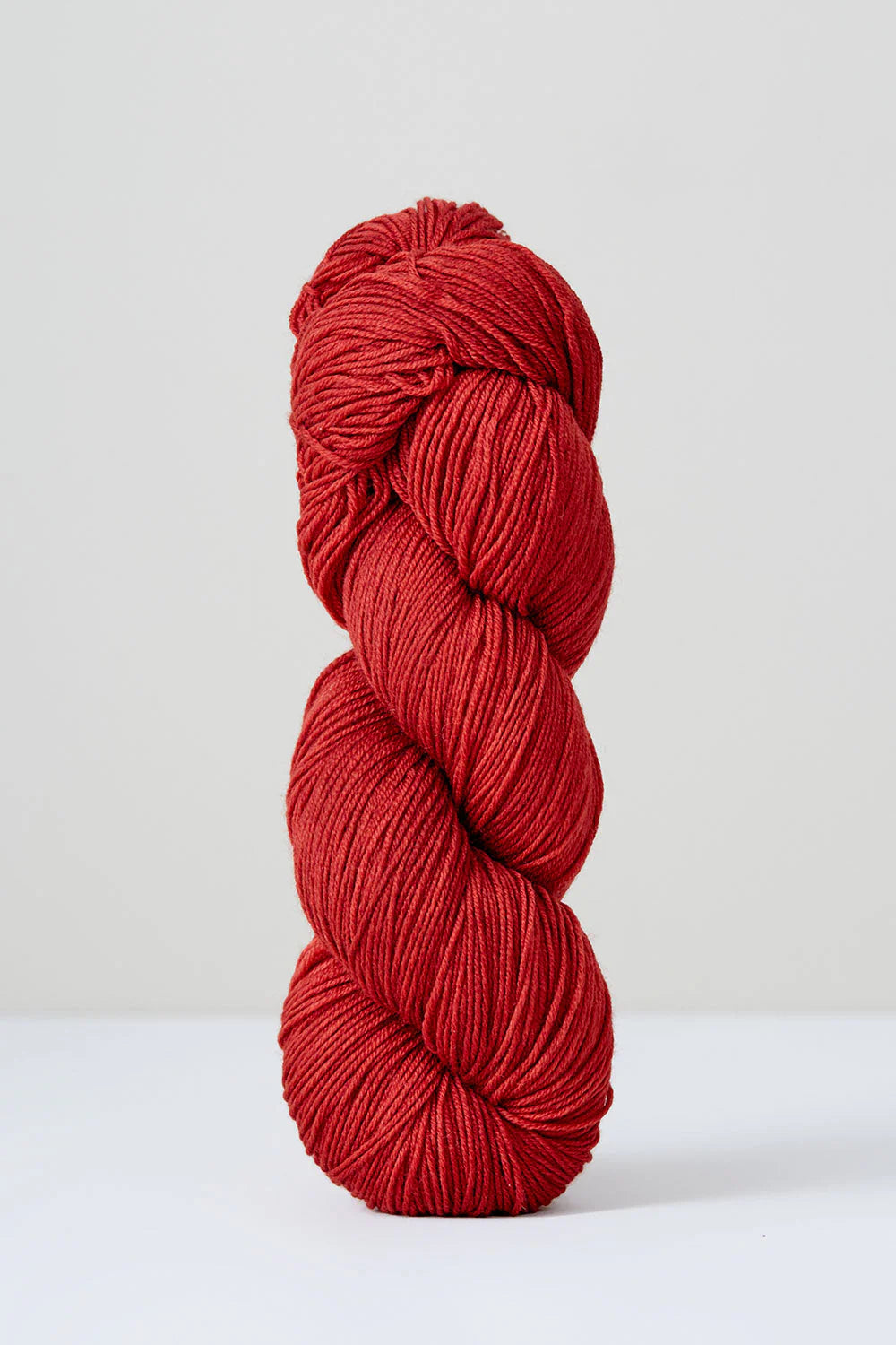 A skein of red superwash merino wool from Urth 