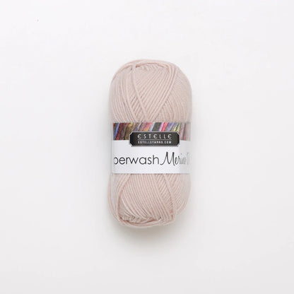 A skein of light pink Superwash merino wool DK yarn labeled 'Superwash Merino DK' by 'Estelle'.