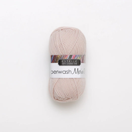 A skein of light pink Superwash merino wool DK yarn labeled 'Superwash Merino DK' by 'Estelle'.
