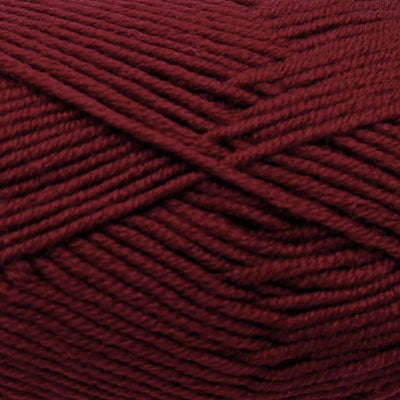 A skein of Estelle Superwash Merino DK wool yarn in Merlot red color.