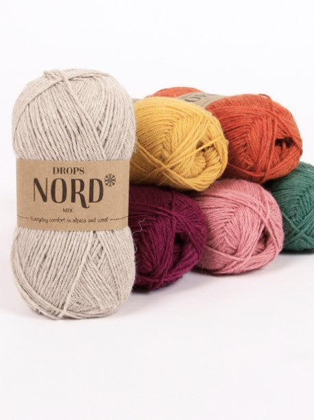 A collection of colorful yarn skeins labeled 'DROPS NORD' arranged neatly, representing different colors available for purchase.